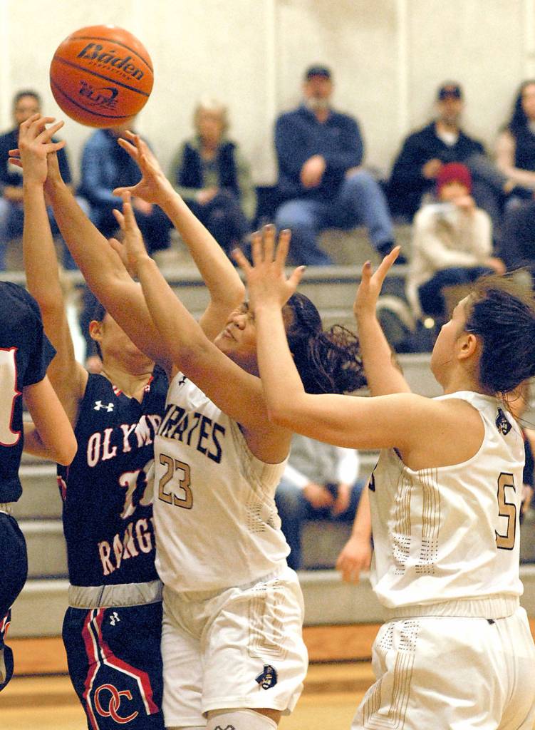 Keith Thorpe/Peninsula Daily News Peninsulas Sunshine Vicente, center battles for a rebound with Olympics Katie Campana, left, as Vicentes teammate Kuutuuq Danner, right, looks on during Saturdays game in Port Angeles.