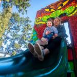 Mary Helgeson and her 2-year-old daughter Kamrynn go down a slide at the Dream Playground in Port Angeles. (Jesse Major/Peninsula Daily News)