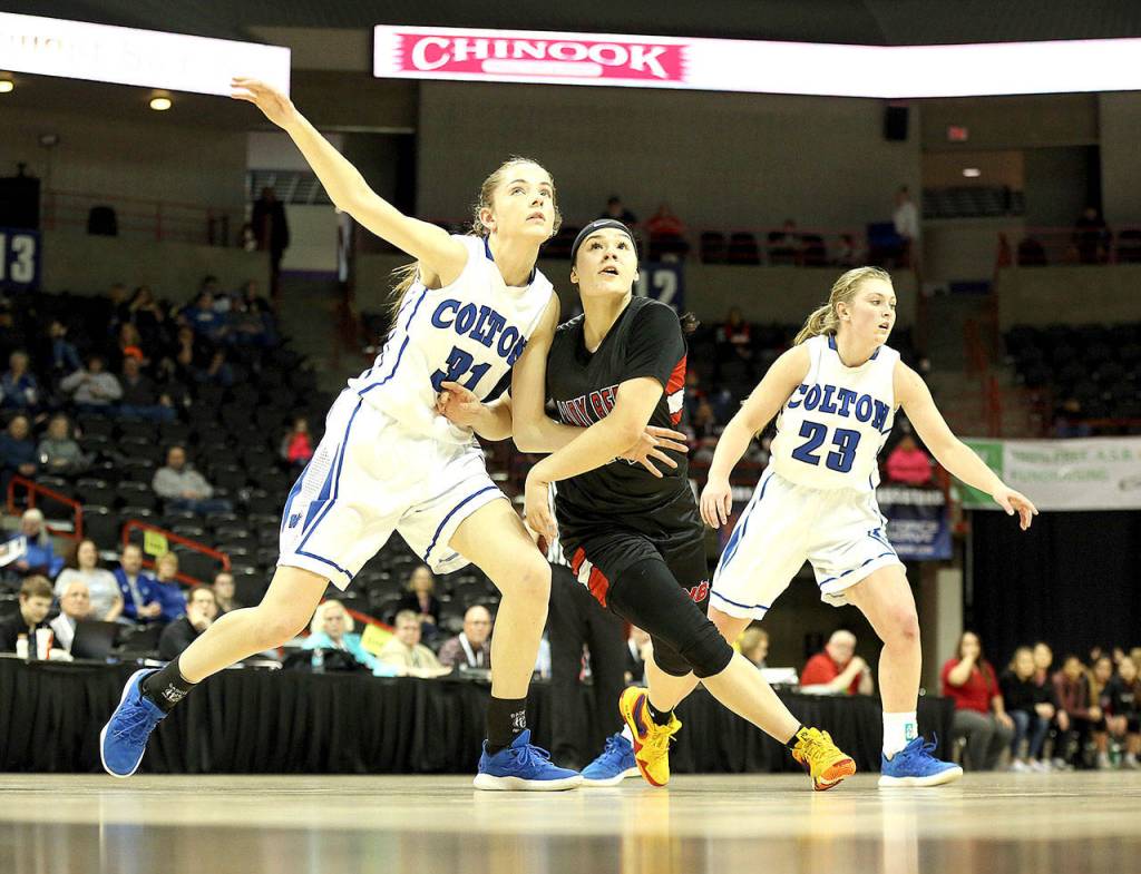 Neah Bays Patience Swan battles with Coltons Emily Schultheis for rebounding position in the girls Class 1B State Basketball Semifinals in Spokane on Friday. Also in on the play is Coltons Jordyn Moehrle. Colton won the game 83-38, sending Neah Bay to the third-place game. (Chris Johnson/for Peninsula Daily News)