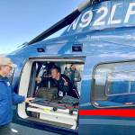Alan Barnard, Port Angeles Disaster Air Response Team coordinator, looks on as Life Flight crew member/paramedic Nick Lane prepares the companys helicopter to assist with emergency response efforts at the scene of the logging helicopter crash.