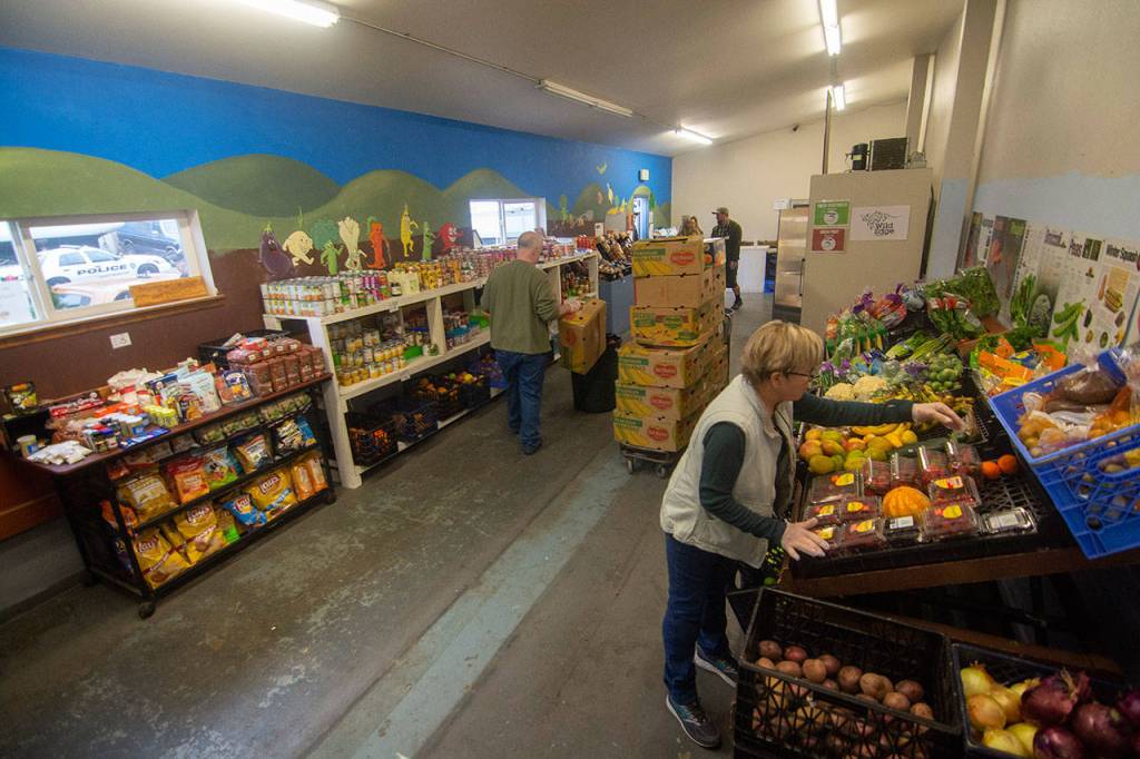 Volunteers stock the shelves at the Port Angeles Food Bank on Monday before distribution. (Jesse Major/Peninsula Daily News)