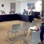 Clallam County Public Utility District Commissioners David Anderson, left, Jim Waddell and Will Purser listen as Assistant Manager John Purvis speaks from the podium. (Rob Ollikainen/Peninsula Daily News)
