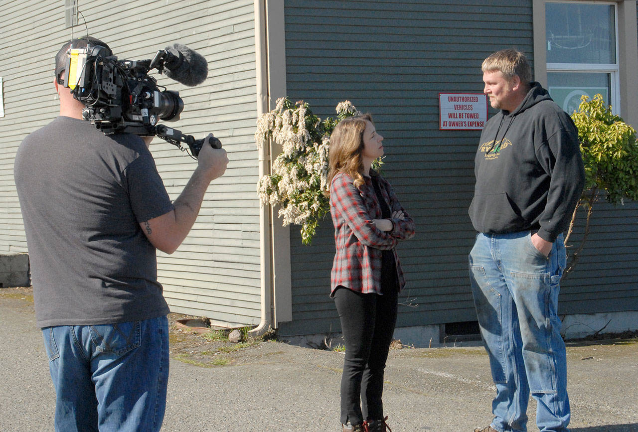 The state Commissioner of Public Lands Hilary Franz, center, speaks with Jason Rygaard of Port Angeles-based Rygaard Logging Inc., as cameraman Brian Andrews of Original Productions tapes their talk Friday for an episode of Ax Men Reborn on the History Channel, set to premiere later this year. (Keith Thorpe/Peninsula Daily News)