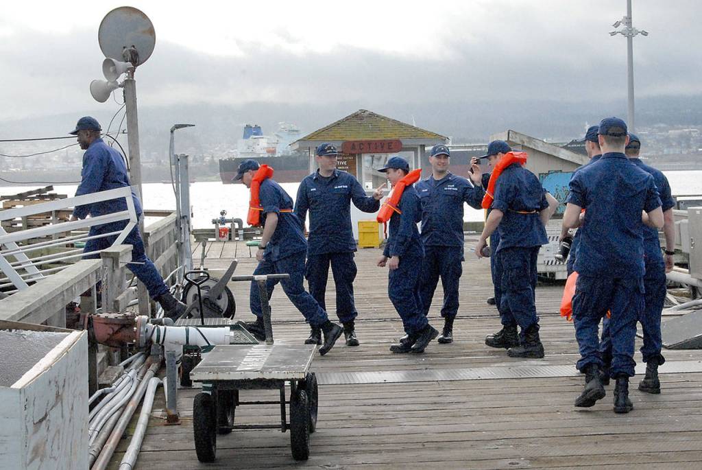 Tsunami evacuation drill participants are ushered onto a waiting Puget Sound Pilots boat at the pier at U.S. Coast Guard Air Station/Sector Field Office Port Angeles. (Keith Thorpe/Peninsula Daily News)