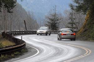Keith Thorpe/Peninsula Daily News Cars make their way around a curve on U.S. Highway 101 at Lake Crescent west of Port Angeles on Wednesday.