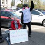 Lannie Johnson sits in front of the state Capitol building where she has been on a hunger strike to save the Southern Resident orcas. She is joined by a supporter, Phil Myers, who is dressed in an orca suit. (WNPA)