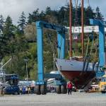 Crowds follow as the schooner Adventuress makes its way across the boatyard in Port Townsend. (Jesse Major/Peninsula Daily News)