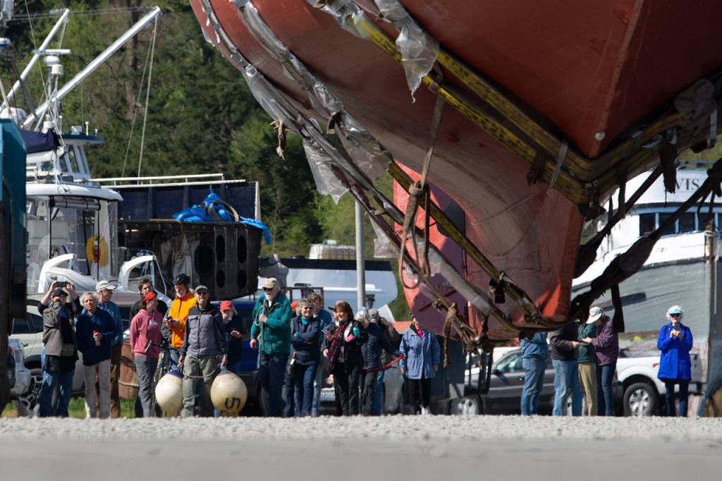 Crowds follow as the schooner Adventuress makes its way across the boatyard in Port Townsend. (Jesse Major/Peninsula Daily News)