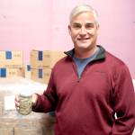 Scott Kimmel holds a jar of pickled herring that will cross the Hood Canal and be sold as Poulsbo Pickled Herring. (Brian McLean/Peninsula Daily News)