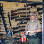Clallam County Sheriffs Deputy Bill Cortani stands in FREDS Guns in Sequim on Sunday morning after someone used heavy equipment to break into the store overnight. (Jesse Major/Peninsula Daily News)