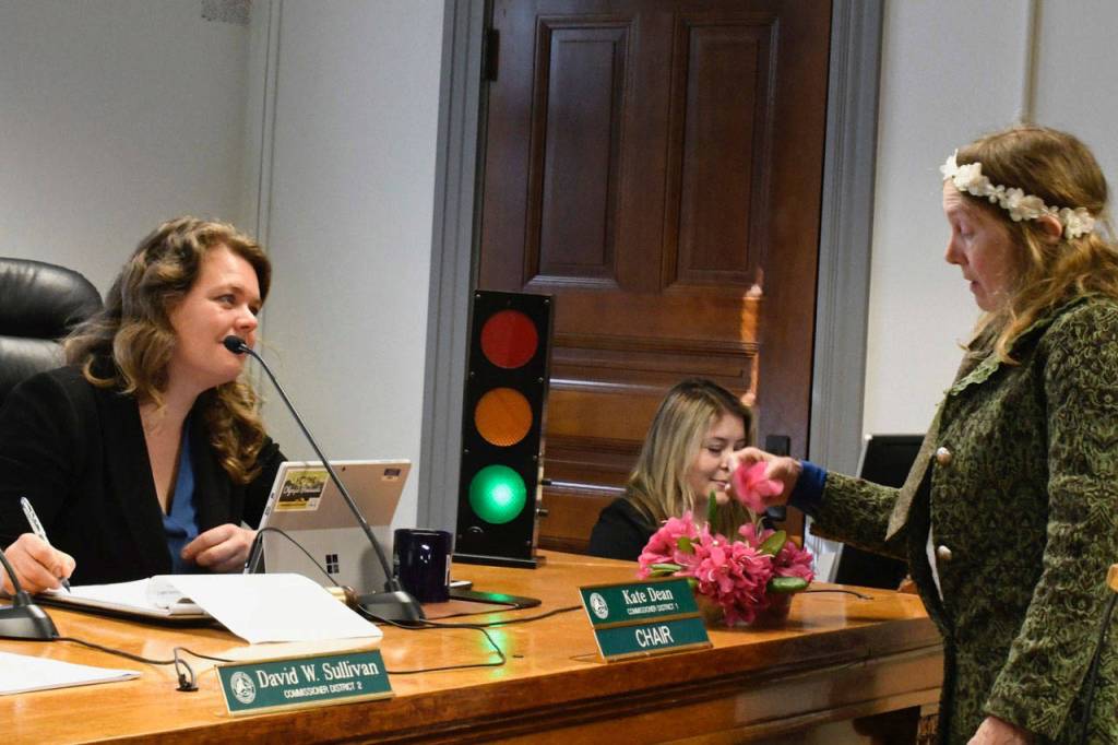 Jana Hoffman Allen of Port Townsend presents the Jefferson County commissioners with a display of rhododendrons Monday. She said that to the children of Port Townsend the Rhody Festival is right up there with Christmas; its pretty close. She urged commissioners to find a solution for the carnival that would keep it downtown. (Jeannie McMacken/Peninsula Daily News)