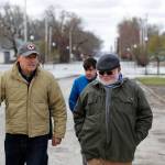 Gov. Jay Inslee, left, walks with climate analyst John Davis of Hamburg, Iowa, while touring flood damage Friday, April 12 in Hamburg, Iowa. (Charlie Neibergall/The Associated Press)