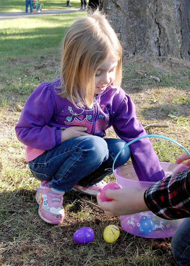 Three-yearold Diana French, along with her mother, Christina French of Port Angeles, looks over her collection of eggs at the end of the KONP Easter Egg Hunt on Saturday. (Keith Thorpe/Peninsula Daily News)