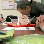 Barbara Sachi, left, and Dave Sachi, both from Port Townsend, look through small magnifying glasses to examine organic compost during a workshop Monday at the Food Co-op Annex. (Brian McLean/Peninsula Daily News)