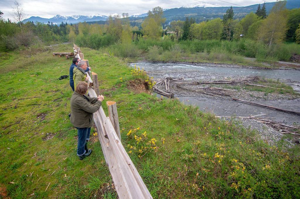 Officials look down at the Dungeness River during the tour. (Jesse Major/Peninsula Daily News)