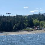A helicopter hovers near the site of an aircraft crash at Discovery Bay on Sunday. (East Jefferson Fire-Rescue Marine Unit)