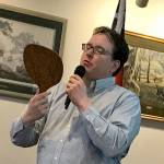 At a presentation Tuesday, Black Ball Ferry Line co-owner Ryan Malane reads from a decades-old hand-held fan that promoted the Olympic Loop scenic route in 1931, when the company ran ferry service now operated by Washington State Ferries. (Paul Gottlieb/Peninsula Daily News)