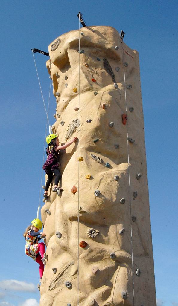 Alivia Cummings of Sequim, top, and Annabelle Deleglise of Paris, France, both 6, try to ascend a climbing town during Saturdays Irrigation Festival Family Fun Day in downtown Sequim. (Keith Thorpe/Peninsula Daily News)