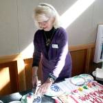 JoAnn Bussa, who has been on the board for the Jefferson County Historical Society for 20 years, cuts the birthday cake Friday at the Northwest Maritime Center during a ceremony to celebrate the societys 140th anniversary. (Brian McLean/Peninsula Daily News)
