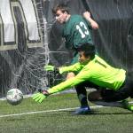 Keith Thorpe/Peninsula Daily News Port Angeles Stuart Methner, top, slips the ball past Foster goalkeeper Sao Lar for a Roughrider point in the first half of Saturdays playoff game at Peninsula College in Port Angeles.