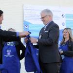 Sequim School District Superintendent Gary Neal, right, receives an honorary apron from Bernie ODonnell, vice president/northwest area manager for Vanir, as school representatives and officials celebrate the opening of the Sequim School Districts new central kitchen March 26. (Michael Dashiell/Olympic Peninsula News Group)