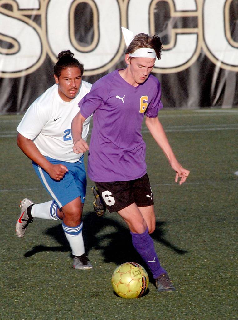 Keith Thorpe/Peninsula Daily News Chris Morgan of Sequim, right, slips past the defense of Washingtons Ariano Taitague Chavez on Tuesday at Peninsula College in Port Angeles.