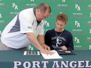 <strong>Keith Thorpe</strong>/Peinsula Daily News                                Port Angeles High School athletic director Dwayne Johnson, left, goes over paperwork on Wednesday with Andrew St. George as the senior signs a letter of intent to attend Peninsula College.