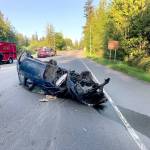 Jefferson County Sheriffs Deputy Adam Newman surveys the damage to the blue BMW driven by a California man who was ejected from the vehicle Wednesday night on state Highway 116 near Oak Bay Road. The man was airlifted to Harborview Medical Center in Seattle. (Jefferson County Sheriffs Office)