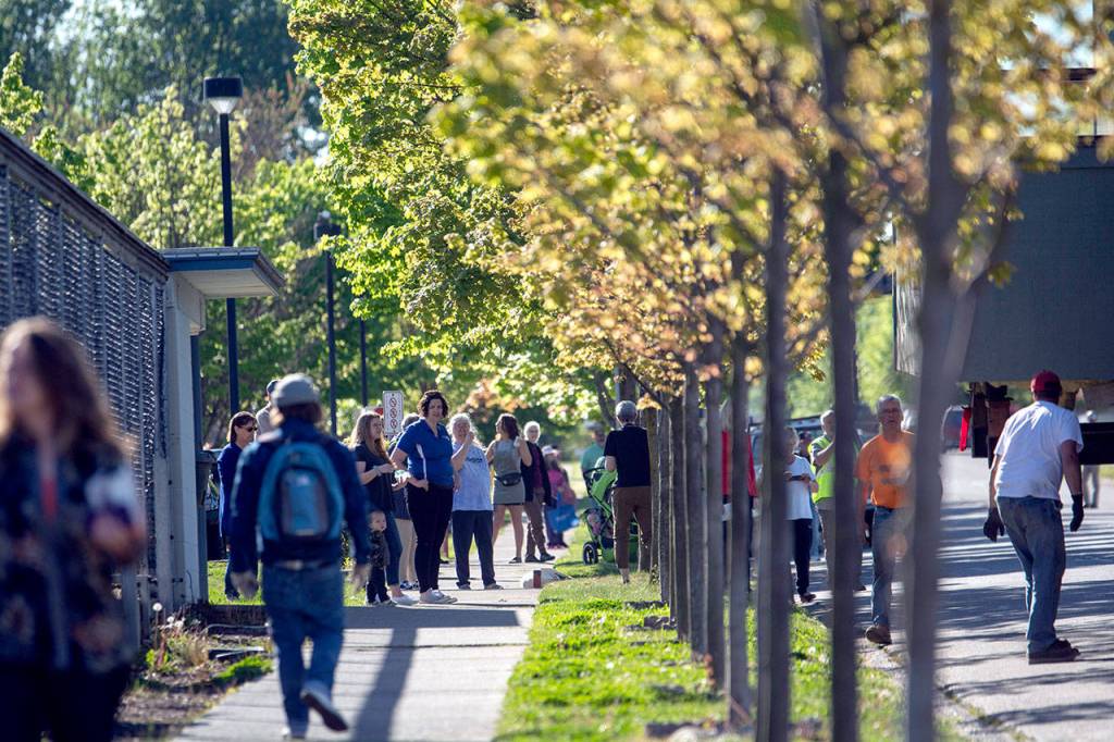 People line East Fifth Street to watch the Horizon Center move down the road. (Jesse Major/Peninsula Daily News)
