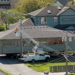 Utility crews raise cable television and telephone lines as the Horizon Center building is pulled underneath on Chase Street in Port Angeles on Thursday. (Keith Thorpe/Peninsula Daily News)