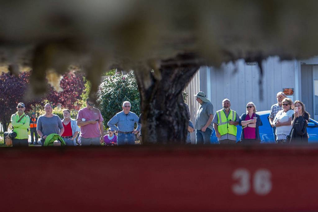 People watch as the Horizon Center moves down East Fifth Street on Thursday. (Jesse Major/Peninsula Daily News)