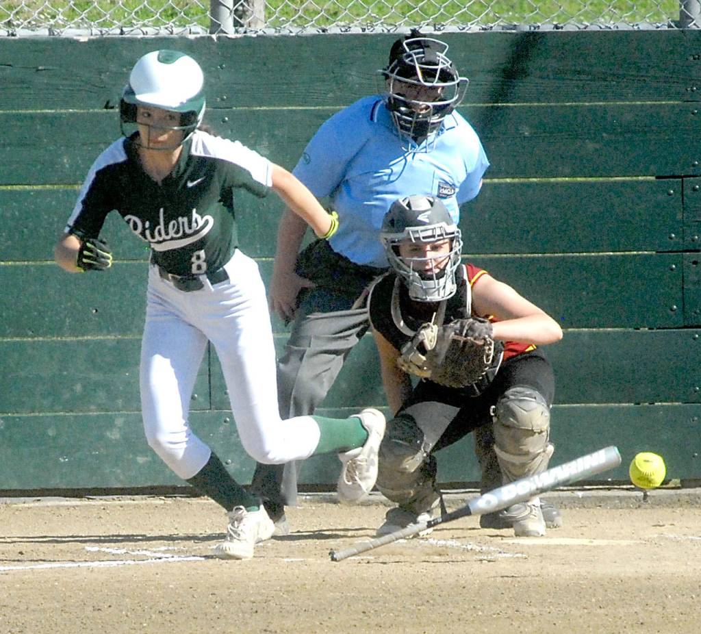 Keith Thorpe/Peninsula Daily News Ella Holland of Port Angele bunts in the second inning as Kingston catcher Meghan Fenwick looks on during Thursdays game in Port Angeles.