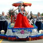 The 2019 Rhododendron Festival royalty, from left, Princess Kaylee Krajewski, Queen Mary Neville and Princess Ellie Thornton ride on their float during Saturdays Irrigation Festival in Sequim. (Keith Thorpe/Peninsula Daily News)