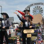 Clallam County Fair Royalty, from left, Princess Rebekah Parker, Queen Saydee Peters and Princess Sammi Bates wave from their fair float on Saturday. (Keith Thorpe/Peninsula Daily News)