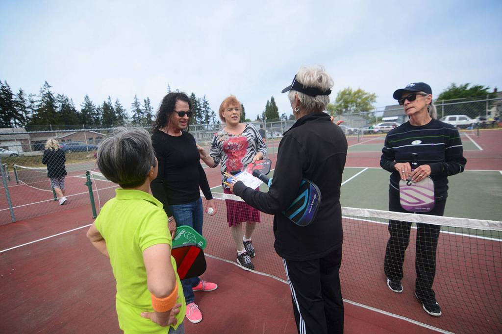 Pickleball players talk after a game during Esprits community pickleball tournament Monday. (Jesse Major/Peninsula Daily News)
