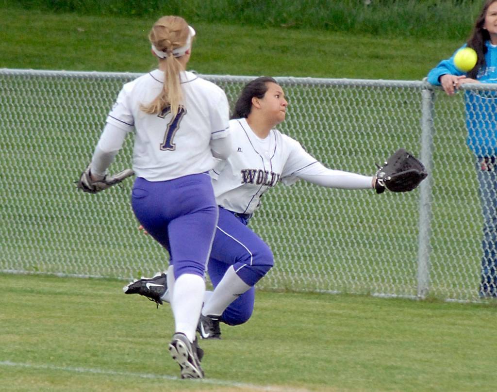 Keith Thorpe/Peninsula Daily News Sequims Lili Fili makes a diving catch in foul territory as teammate Isabelle Dennis looks on in the fifth inning against Port Angeles on Tuesday.
