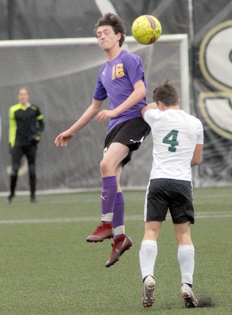 Rudy Franco of Sequim, center, takes a header as Woodlands J.J Fuerst defends in the first period on Wednesday. (Keith Thorpe/Peninsula Daily News)