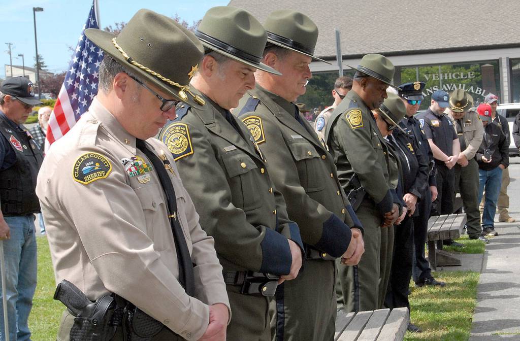 Law enforcment agents, including Chief Criminal Deputy Brian King of the Clallam County Sheriffs Office, front, bow their heads during an invocation during Fridays ceremony at Veterans Park in Port Angeles to honor fallen officers. (Keith Thorpe/Peninsula Daily News)
