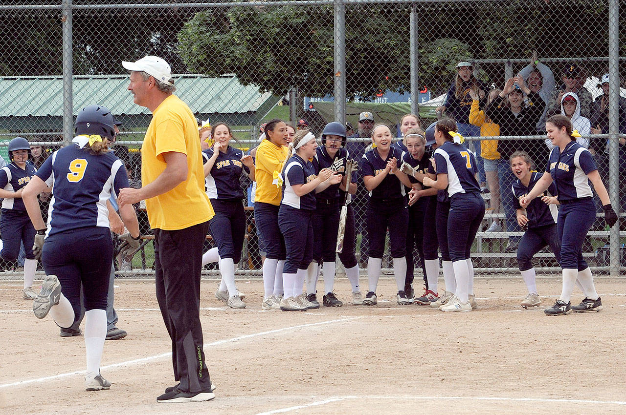 Forks Chole Leverington (9) heads for home after knocking the ball over the left field fence as the Spartans defeated Lynden Christian 5 to 0. Awaiting at home plate are a group of happy Spartans while head Coach Jr. Dean looks on. (Lonnie Archibald/for the Peninsula Daily News)