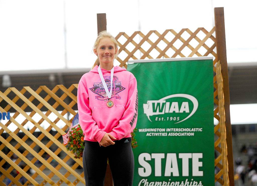 Port Angeles Millie Long shows off her seventh-place medal from the 100-meter hurdles Thursday at the 2A state track and field championships at Mount Tahoma High School in Tacoma. Two days later, Long won the state championship in the 300 hurdles.