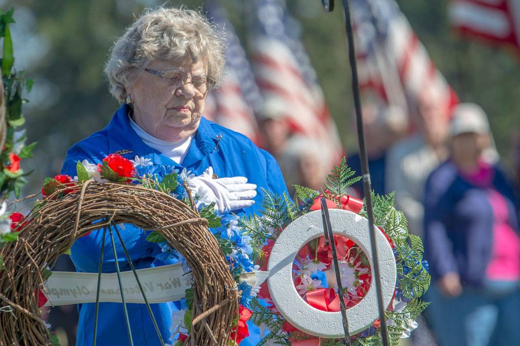 Patricia Foster, representative of the Veterans of Foreign Wars Auxiliary, places her hand over her heart after placing a wreath at the annual Memorial Day service at Mount Angeles Memorial Park in Port Angeles on Monday. (Jesse Major/Peninsula Daily News)
