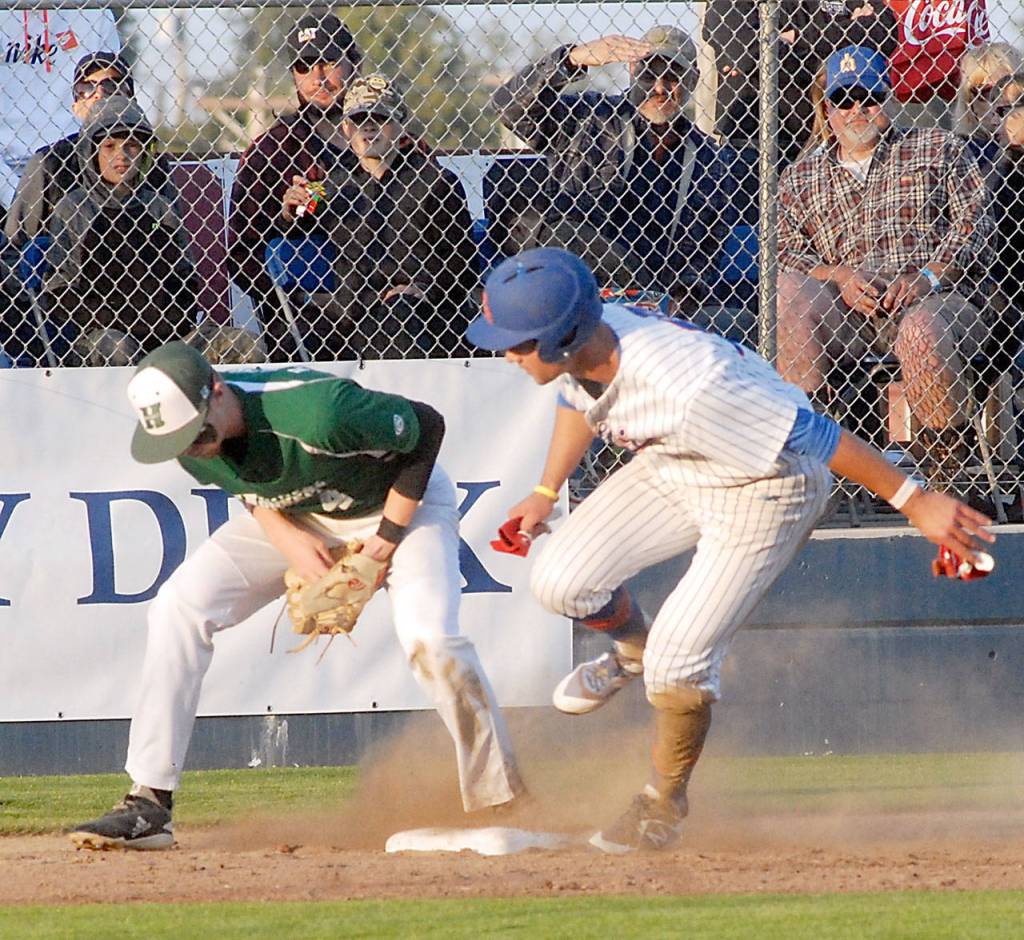Keith Thorpe/Peninsula Daily News Lefties second baseman Damiano Palmegiani dances into third as Northwest third baseman Kendall Yackley bobbles the ball on Thursday evening in Port Angeles.