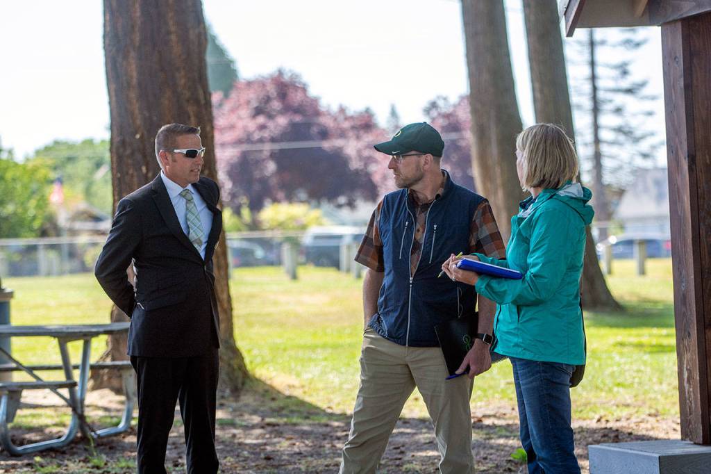 Port Angeles Parks and Recreation Director Corey Delikat, left, Dream Playground Foundation President Steve Methner and Play By Design Project Manager Laura Sehn discuss the new design for the Dream Playground. (Jesse Major/Peninsula Daily News)