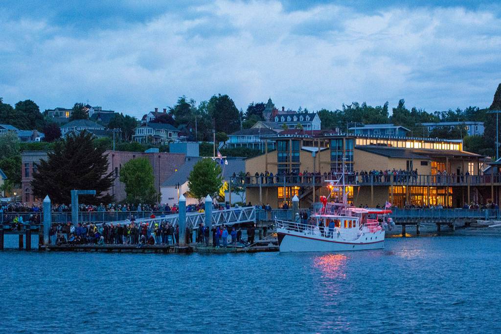 People gather along the shore outside the Northwest Maritime Center in Port Townsend to watch the start of the Race to Alaska on Monday morning. (Jesse Major/Peninsula Daily News)
