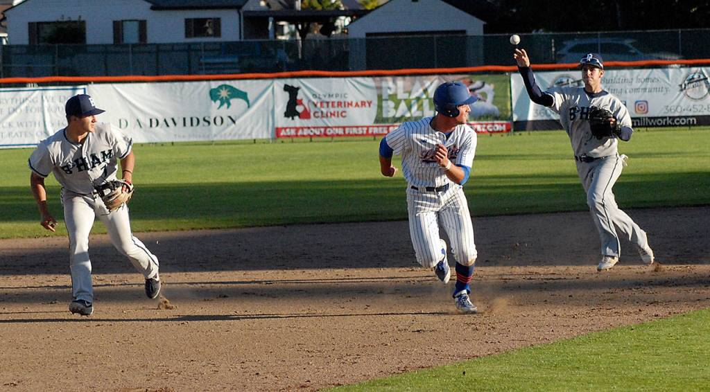 Keith Thorpe/Peninsula Daily News Lefties Damiano Palmegiani, center, gets caught in a rundown between second and third as Bellingham second baseman Mason Margenco, left, looks at the toss from shortstop Collin Burns in the bottom of the third on Friday evening at Port Angeles Civic Field. Palmegiani was forced out on the play.