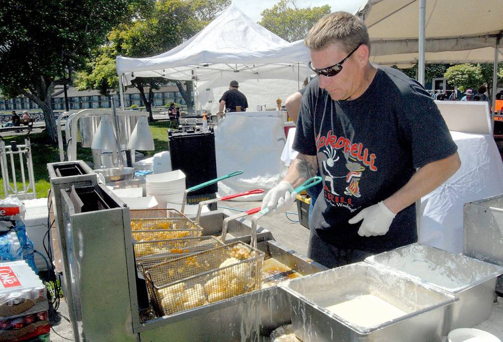 Brian NJennings of Kokopelli Grill cooks fish and chips at a food tent at Port Angeles City Pier on Saturday. (Keith Thorpe/Peninsula Daily News)