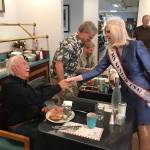 Newly named Ms. Senior USA Cherie Kidd of Port Angeles, a member of the Port Angeles Business Association, greets incumbent Clallam Fire District 2 Commissioner Richard Ruud and primary election challengers Steve Hopf, center, and Keith Cortner, right, at a PABA voter forum Tuesday. (Paul Gottlieb/Peninsula Daily News)