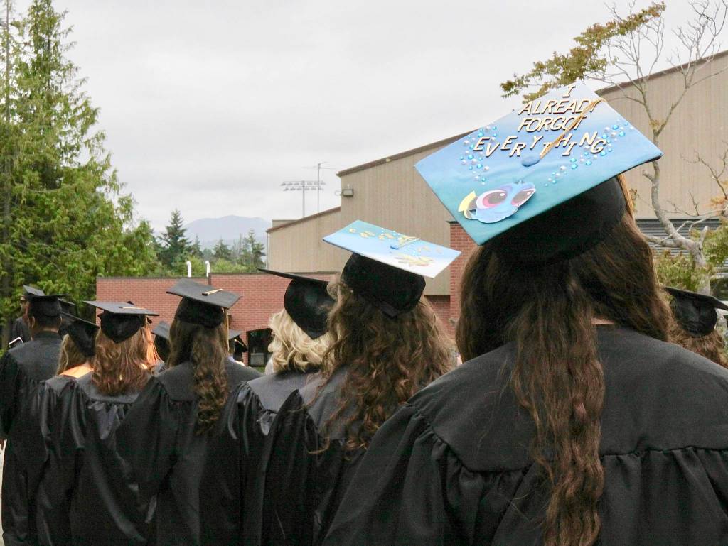 Graduation humor found on the top of a mortarboard as the graduates walk across campus to the ceremony site on the back lawn Saturday at Peninsula College. (Dave Logan/for Peninsula Daily News)
