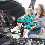 Barron Stangle, 2, of Port Angeles tries his hand at the controls of a Coast Guard helicopter on display at Airport Appreciation Day at Fairchild International Airport on Saturday as his mom, Ariana, watches. This was one of over a dozen displays and attractions at the airport event. (Dave Logan/for Peninsula Daily News)