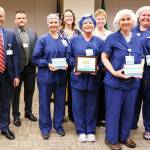 From left, are Olympic Medical Center CEO Eric Lewis, OMC Board President John Nutter, OMC Surgical Services Supervisor Sarah Winfield and Chief Nursing Officer Lorraine Wall with operating room nurses, in scrubs, DeAnn Pype, Joellyn Jensen, Ellen Adams and Heidi Mattern.